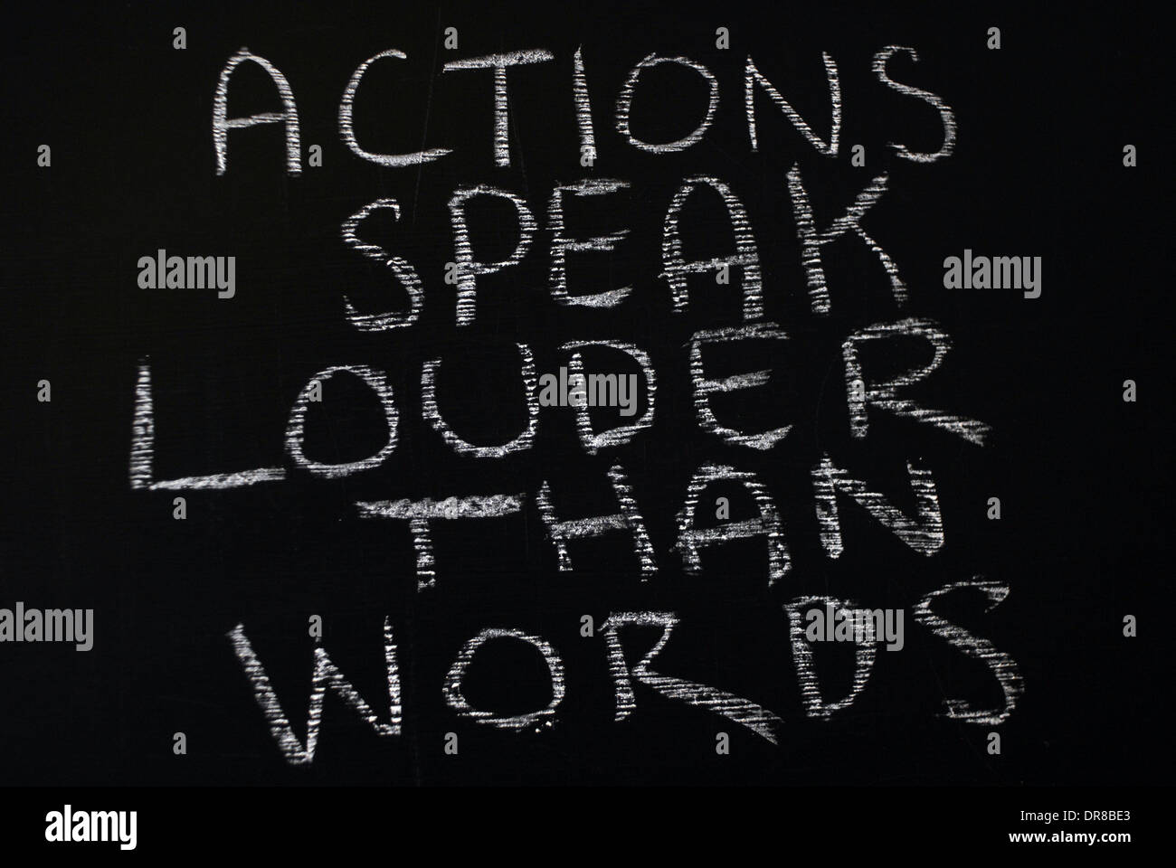Kreide schreiben - Taten sprechen lauter als Worte. -Wörter auf Tafel geschrieben. Stockfoto