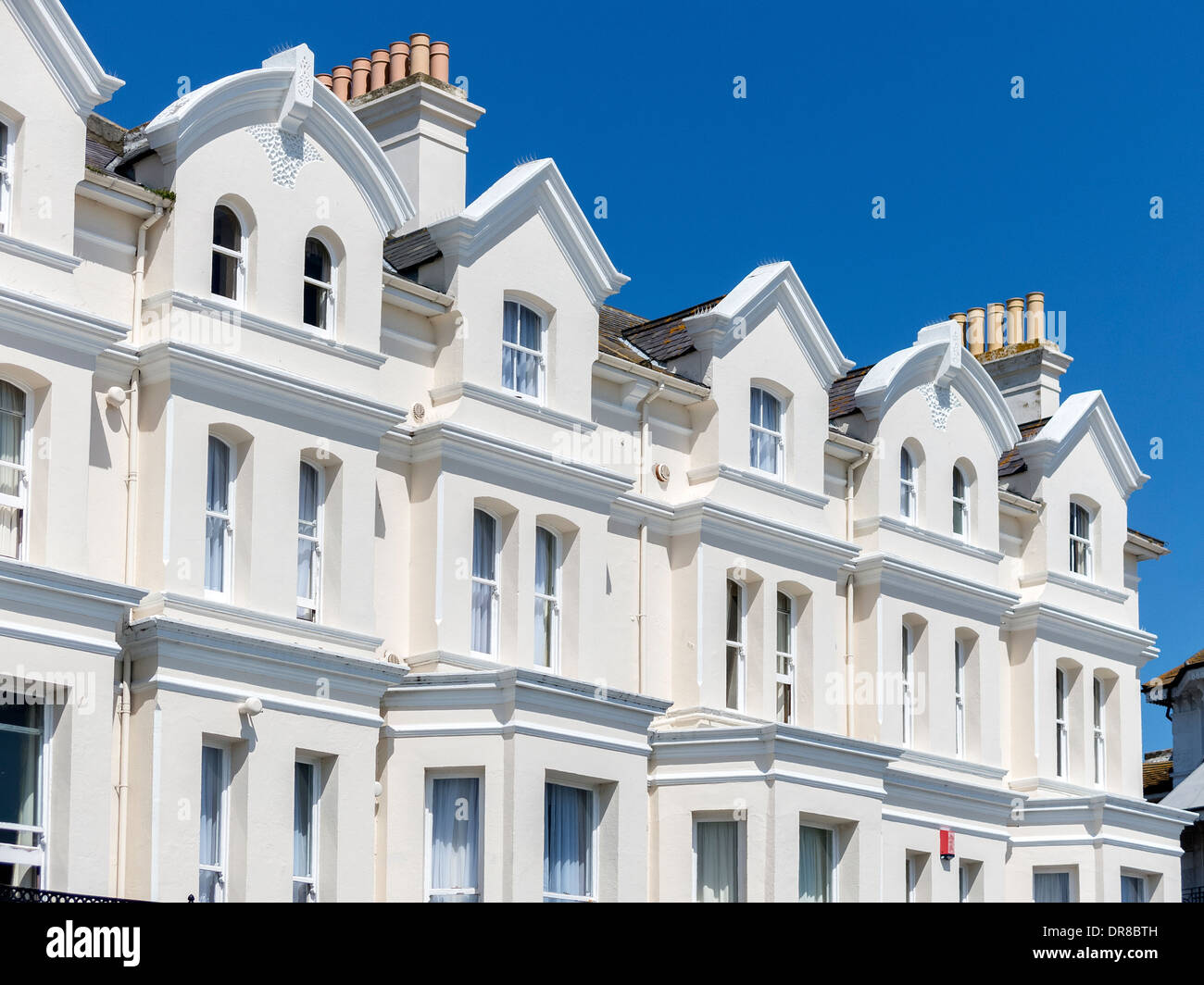 Sonnendurchfluteten weißen gemalten viktorianischen Terrasse direkt am Meer Fassade des York House Hotel, Eastbourne, East Sussex, England, UK Stockfoto