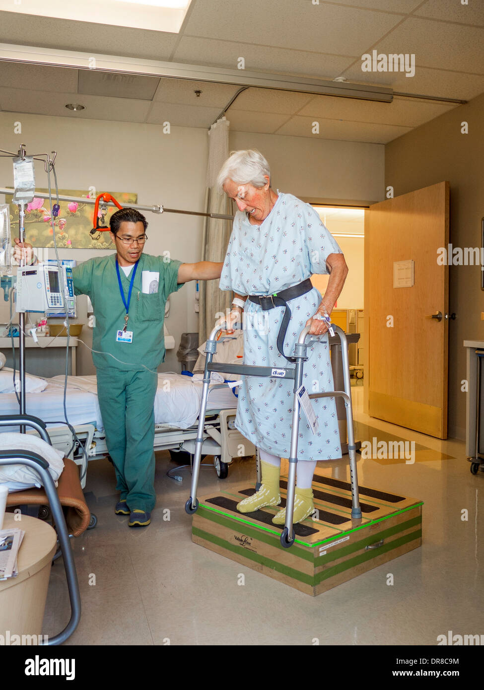 Eine Ergotherapeutin hilft erholt Hüft Chirurgie Patienten in einem Krankenhaus in Südkalifornien eine Gehhilfe zu verwenden. Stockfoto