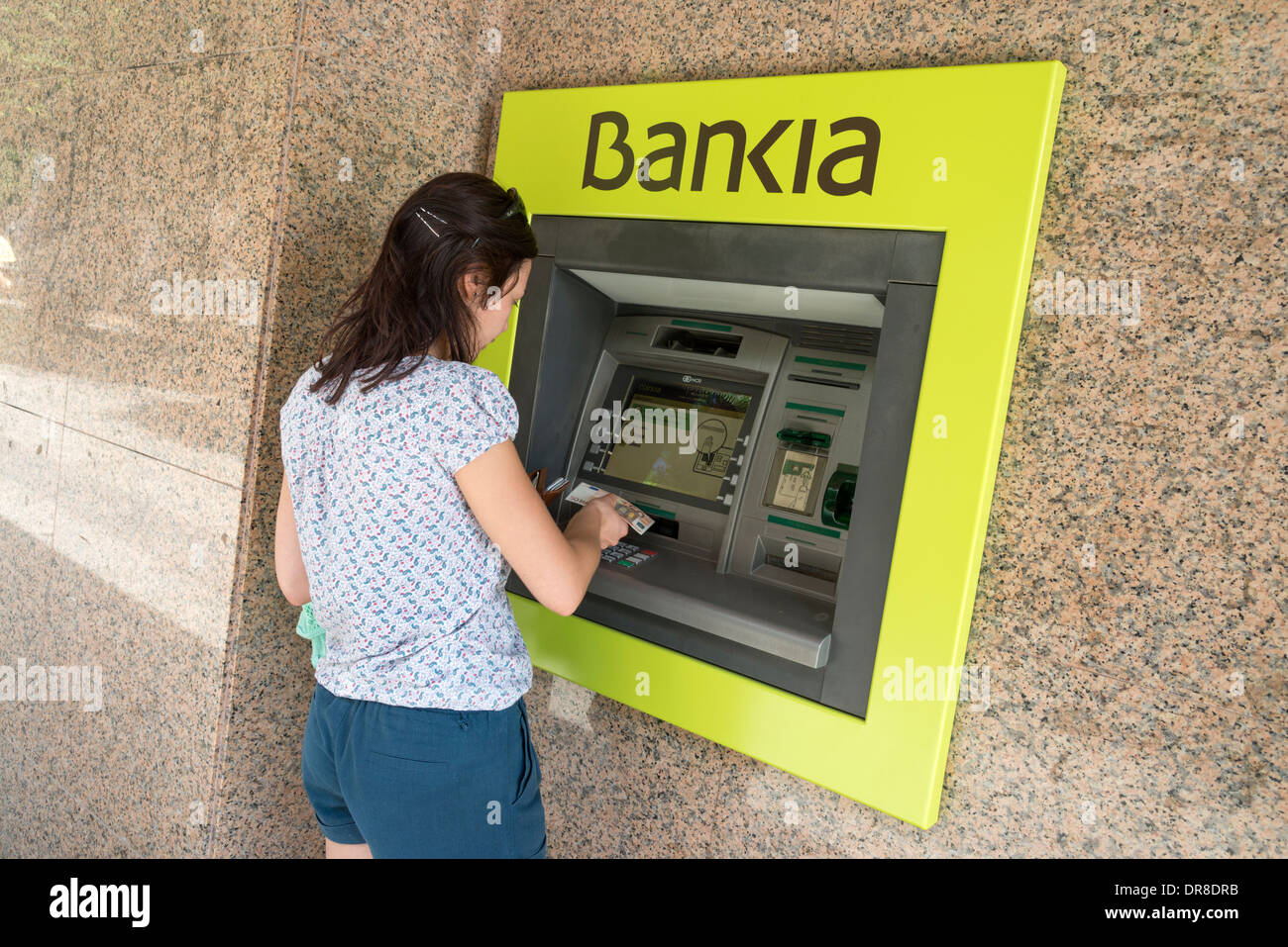 Junge Frau, die Bankia ATM, Spanien Euro entziehen Stockfoto