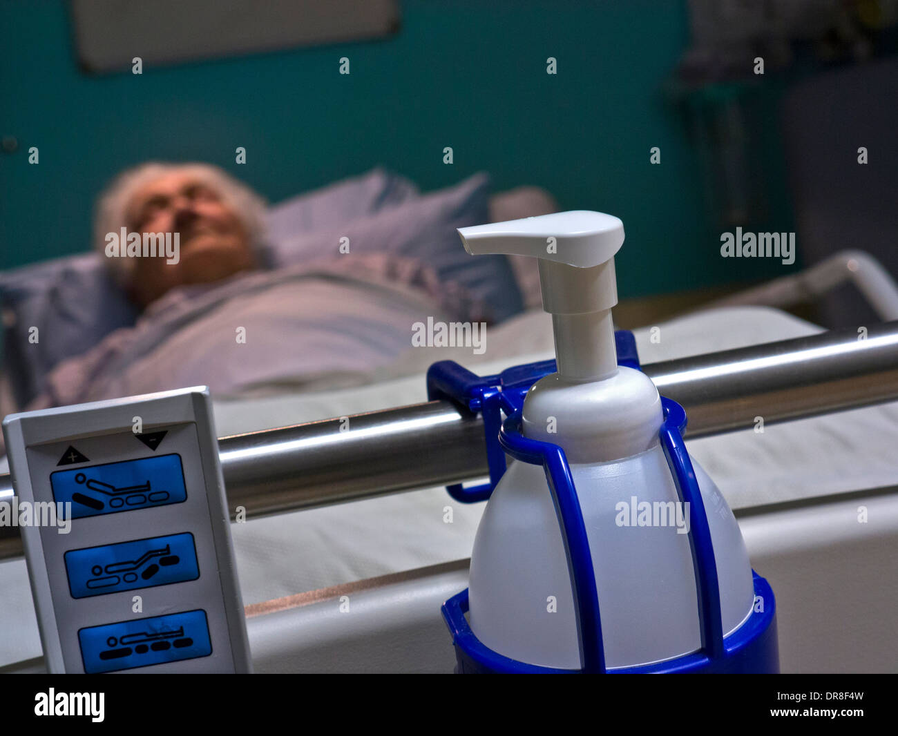 Coronavirus Ältere Dame im Krankenhausbett mit hygienischer Reinigung Covid-19-Krankheitskontrolle antibakterielle Desinfektions-Handwaschflasche im Vordergrund Stockfoto