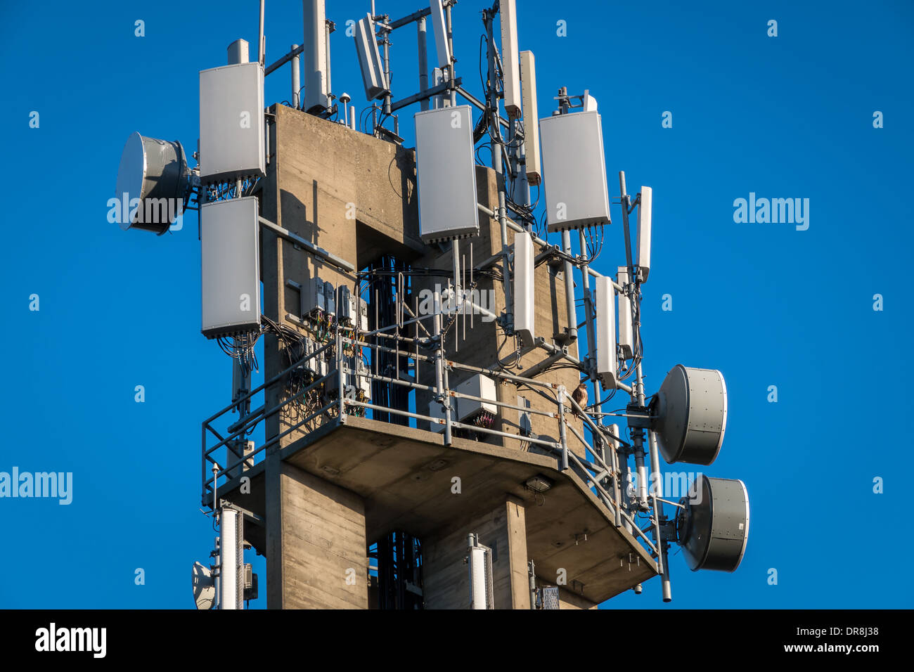 Nahaufnahme von Kommunikations-Turm mit Sender und Empfänger. Redtail Hawk thront auf einem Geländer. Stockfoto