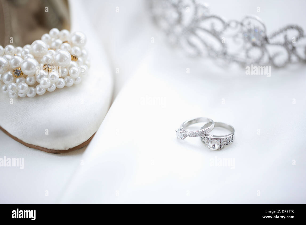 Trauringe und Heels auf Hochzeitskleid Stockfoto
