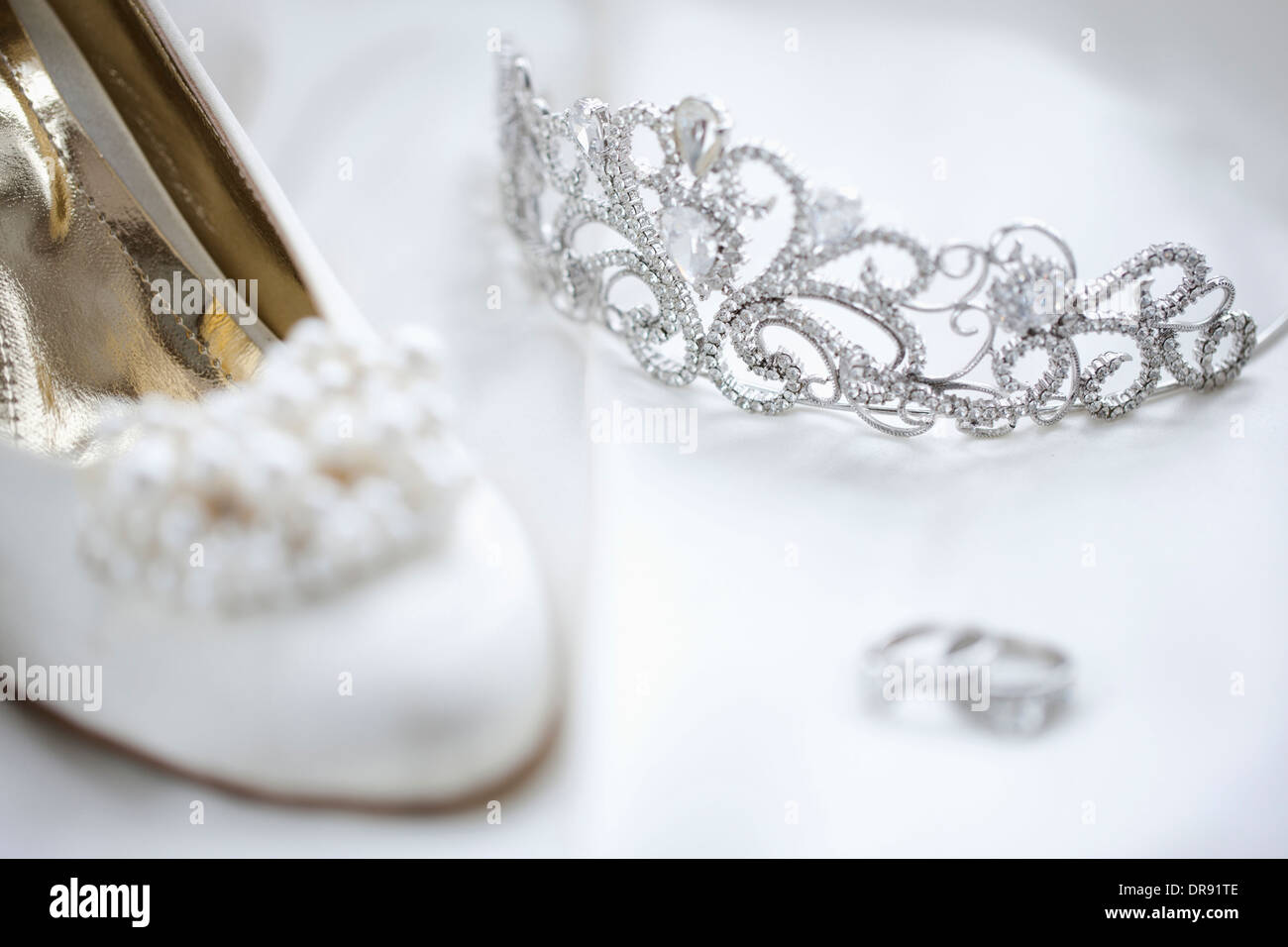 Trauringe und Heels auf Hochzeitskleid Stockfoto