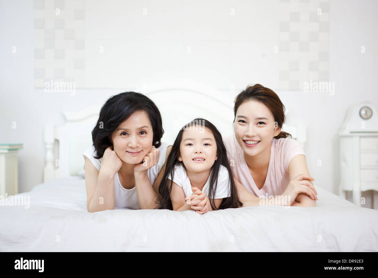 eine Frau mit Tochter und Enkelin auf einem Bett Stockfoto