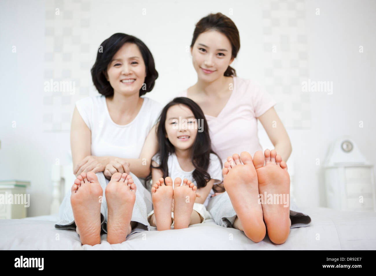 eine Frau mit Tochter und Enkelin auf einem Bett Stockfoto