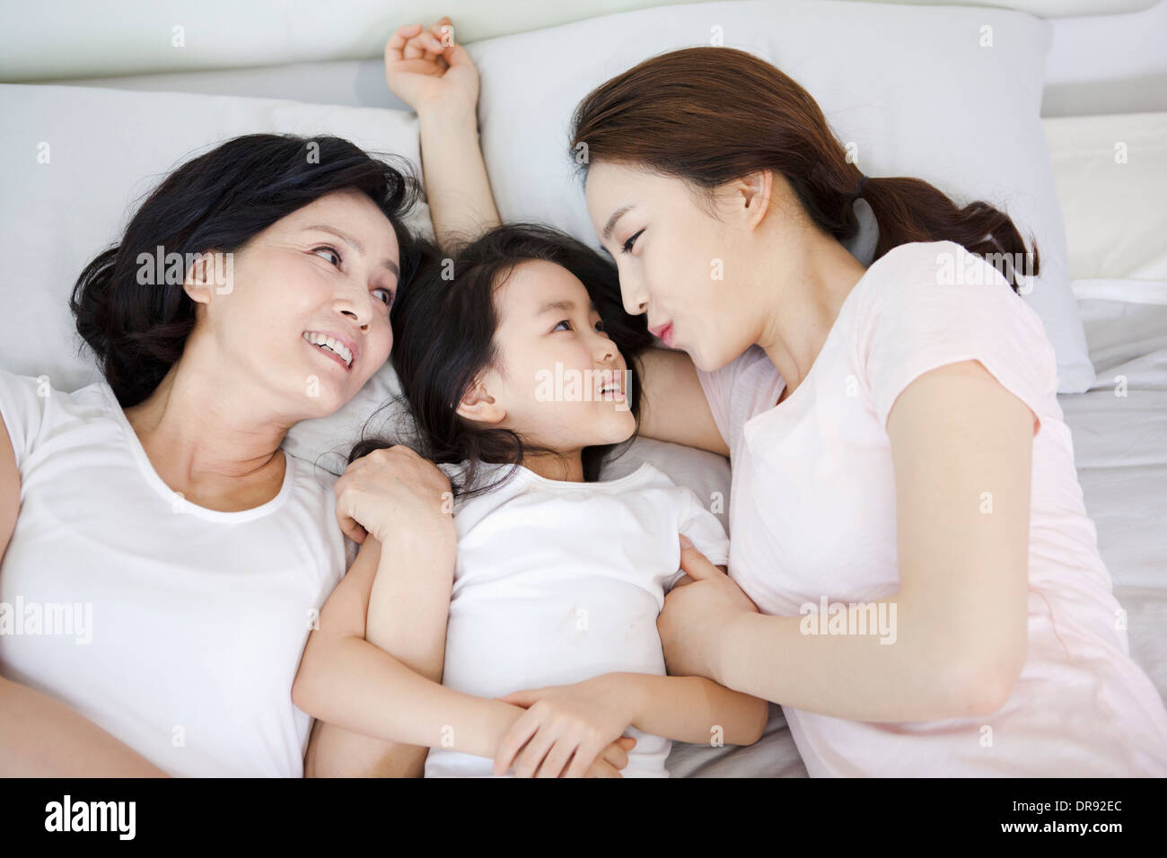 eine Frau mit Tochter und Enkelin auf einem Bett Stockfoto