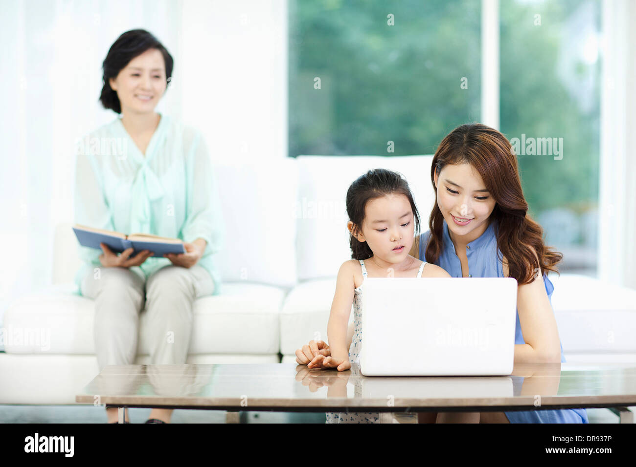 eine Frau, Tochter und Enkelin mit Laptop beobachten Stockfoto