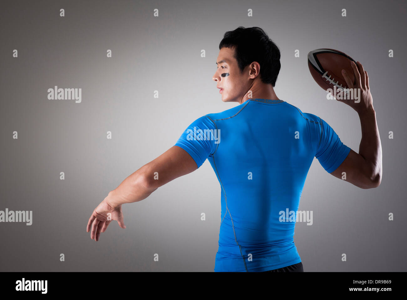ein Fit Mann im blauen Hemd zu einen Rugby-Ball werfen Sie Stockfoto