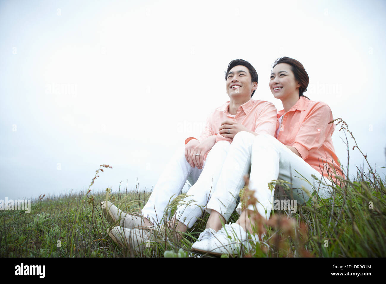 ein Mann und eine Frau sitzen auf einer Wiese Stockfoto