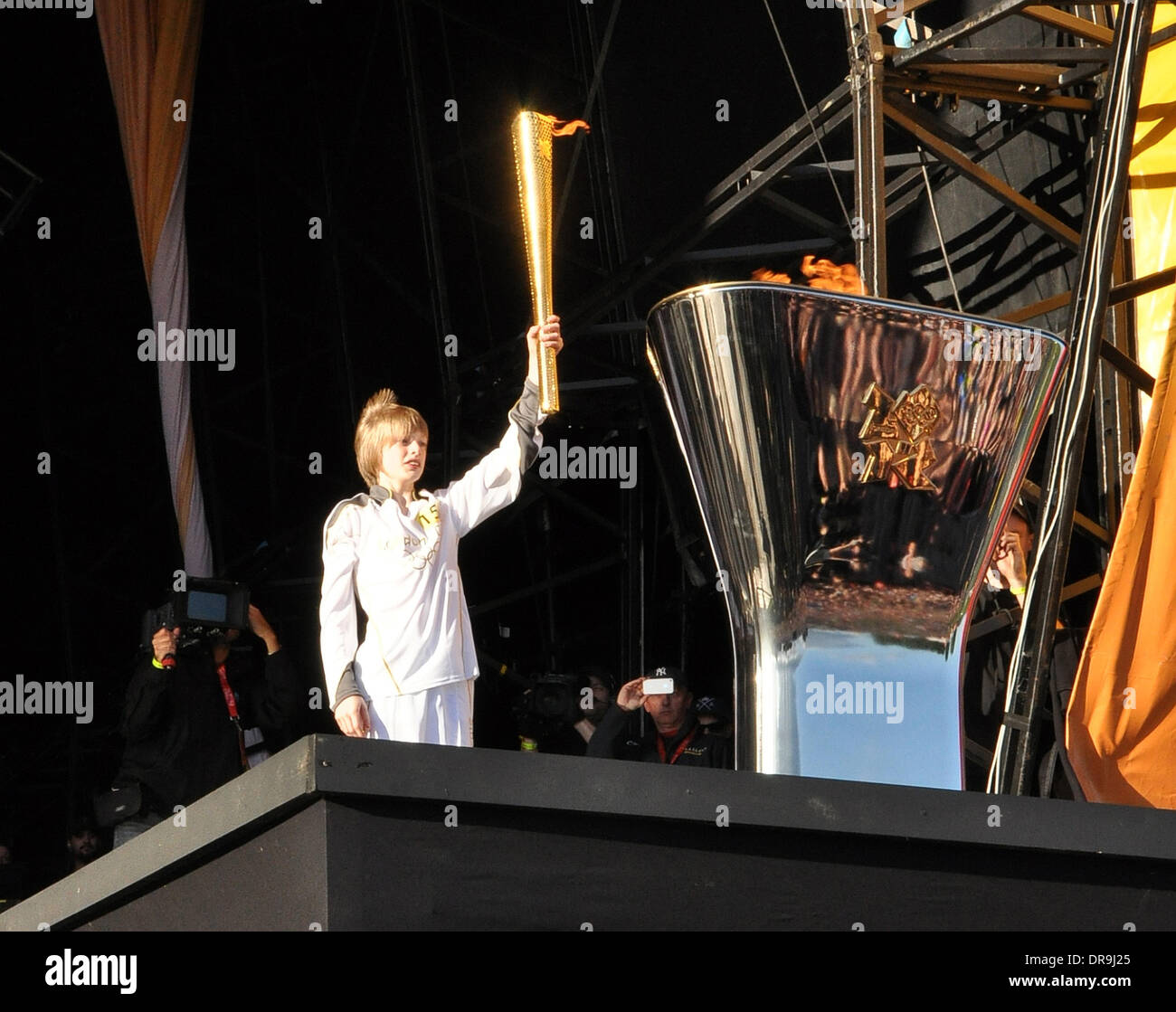 Aaron Bell 13, aus Halifax West Yorkshire trägt die Olympische Fackel und leuchtet den Olympischen Kessel am Temple Newsam in Leeds Leeds, West Yorkshire - 24.06.12 Stockfoto