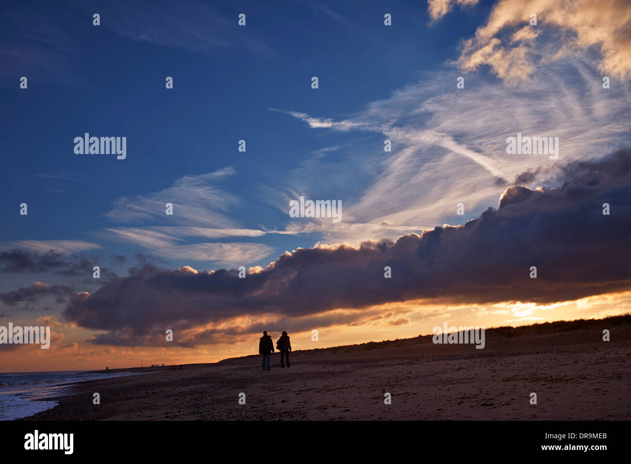 Paare, die am Strand in der Abenddämmerung. Southwold, Suffolk, England. Stockfoto