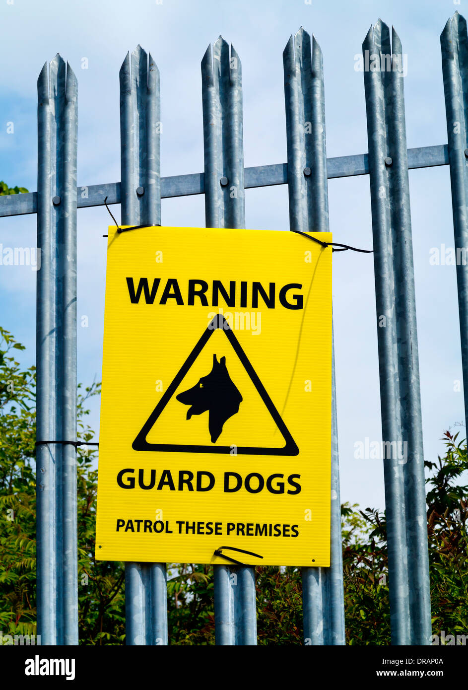 Warnung-Wachhunde patrouillieren diese Räumlichkeiten Zeichen an ein Metall Sicherheitszaun angebracht Stockfoto
