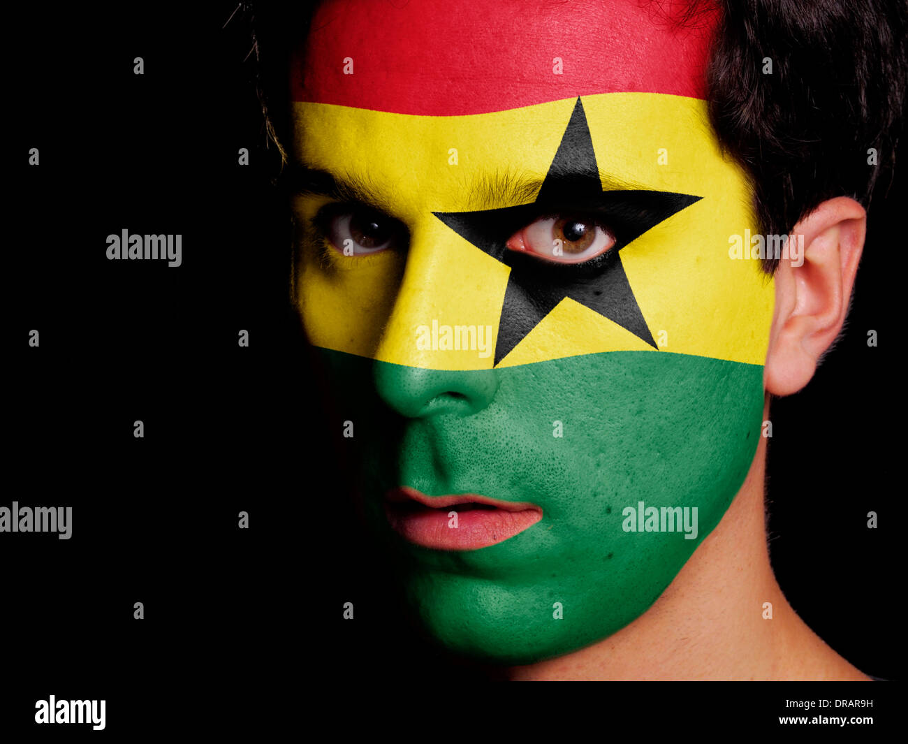 Flagge von Ghana auf ein Gesicht eines jungen Mannes gemalt Stockfoto