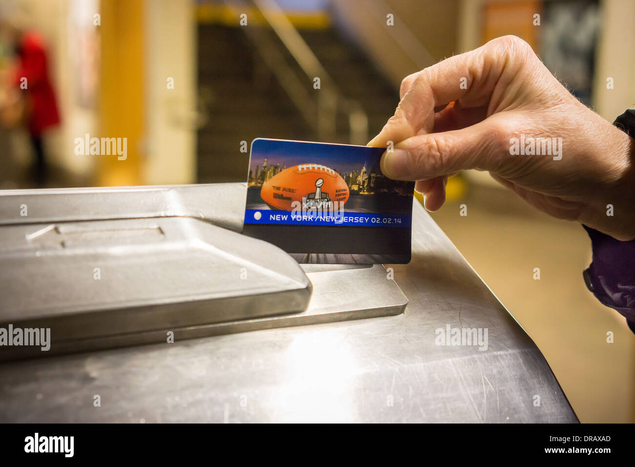 Ein Pendler bereitet sich auf ihre Super Bowl XLVIII Werbe MetroCard durch ein hohes Rad um die u-Bahn in New York geben schieben Stockfoto