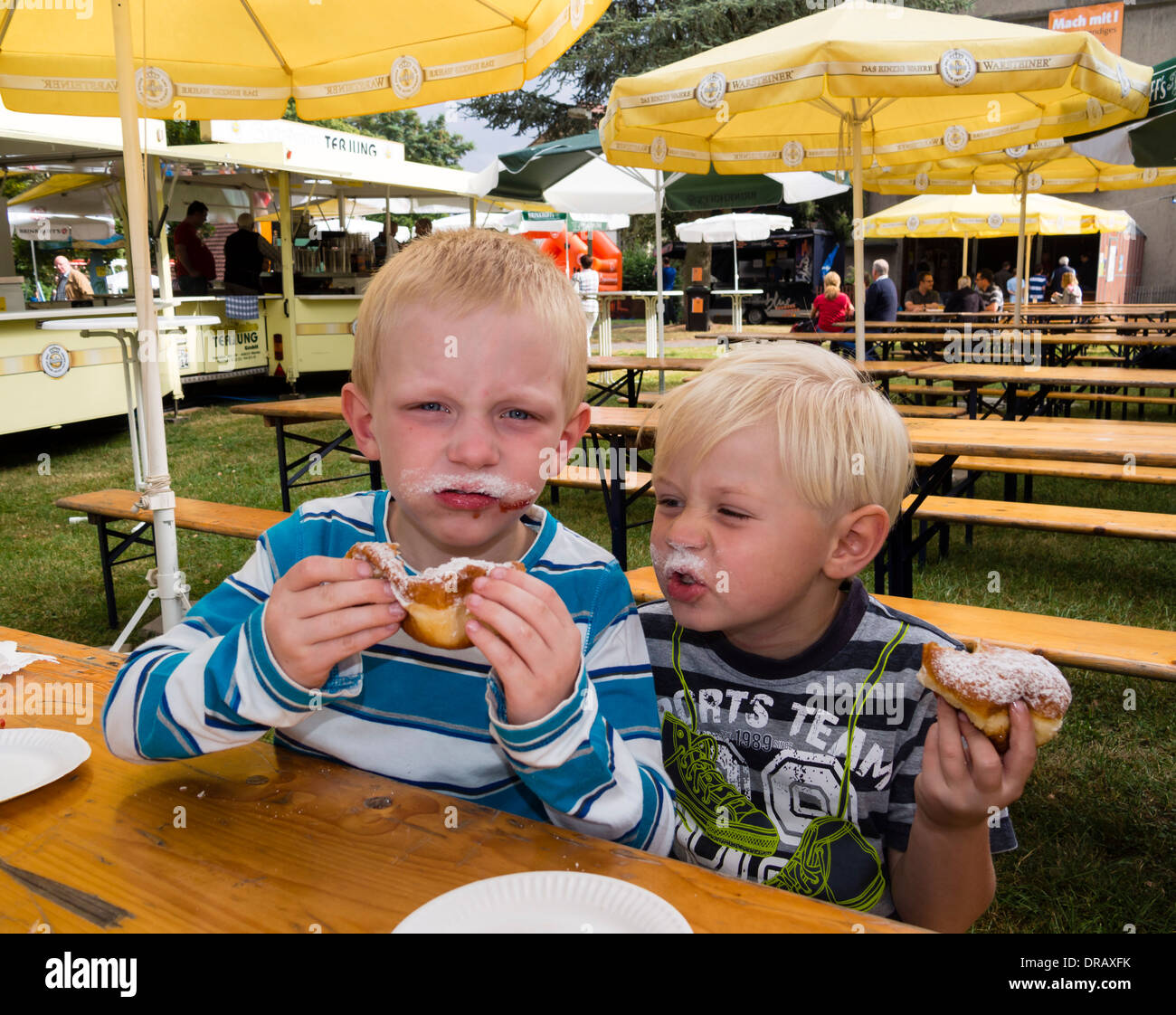 Zwei Brüder, vier und fünf Jahre alt, genießen ihre Donuts. Stockfoto