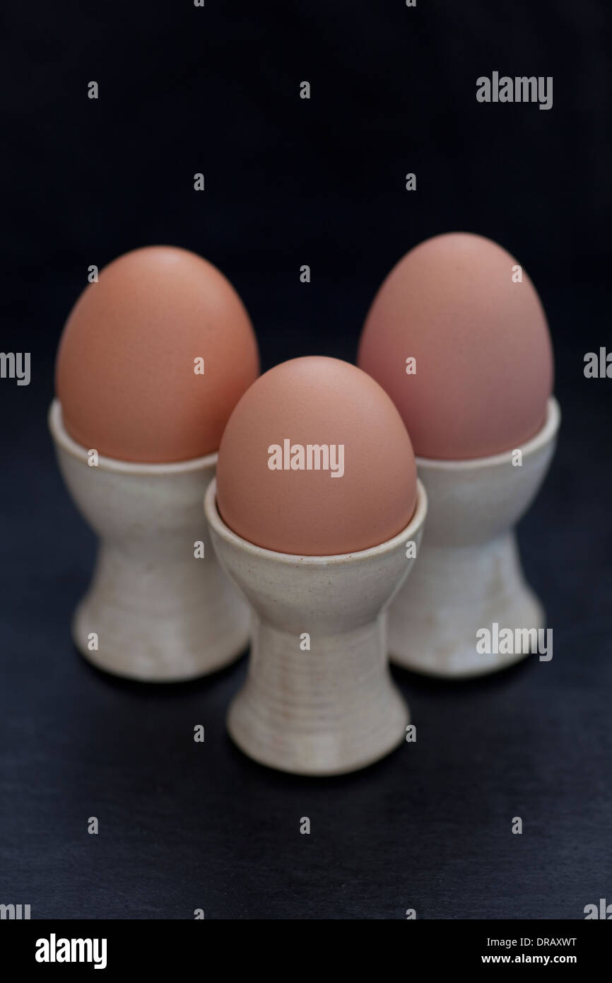 Die drei braunen Hühnereier in der eierbecher. Stockfoto