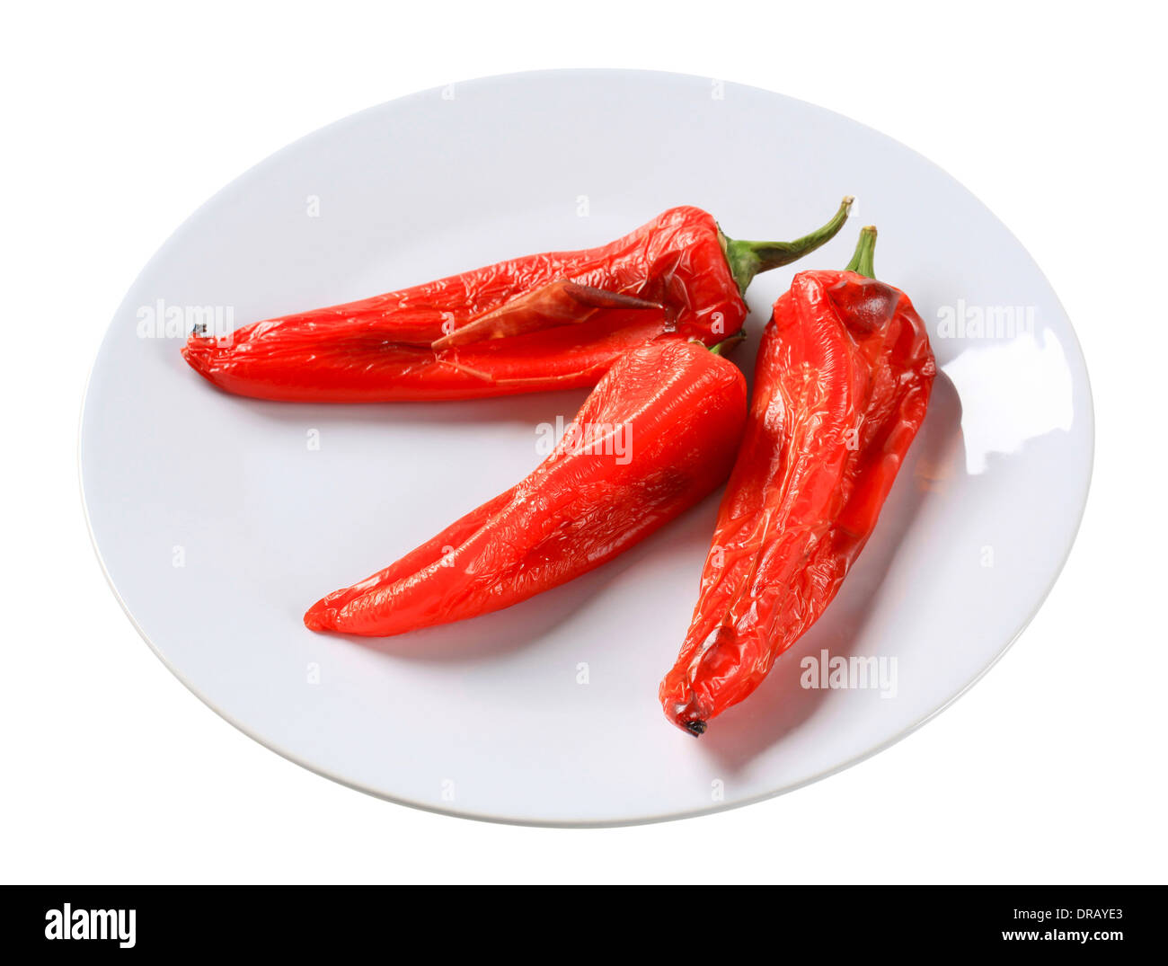 Drei geröstete rote Paprika auf einem Teller Stockfoto