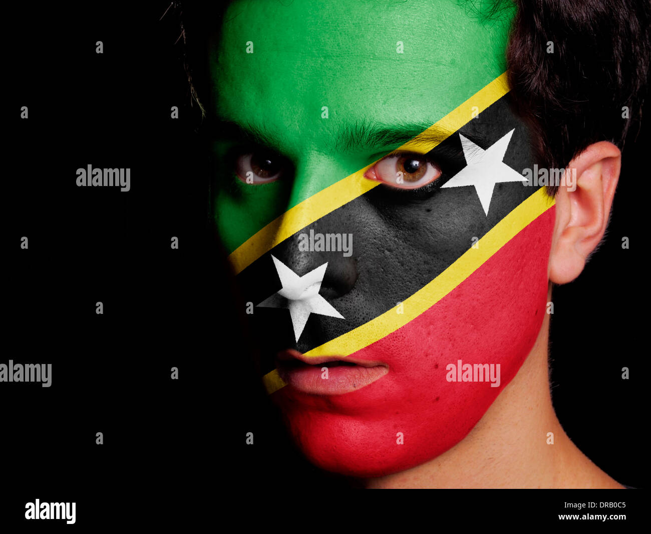 Flagge von Saint Kitts und Nevis auf ein Gesicht eines jungen Mannes gemalt Stockfoto