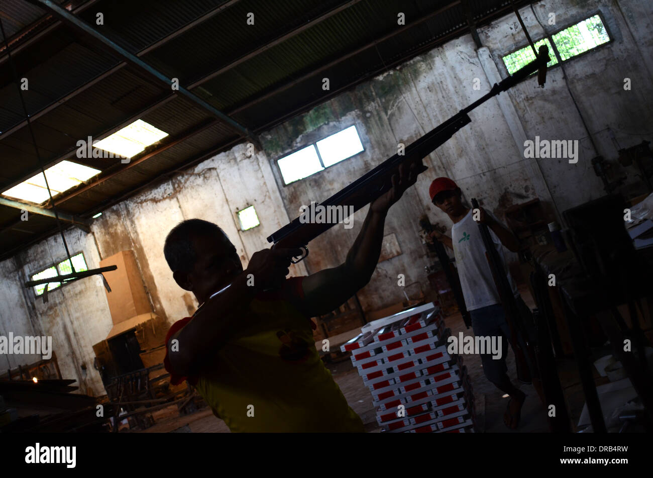 Ein Arbeiter testen die Genauigkeit der Waffe in einer kleinen Fabrik, Bestandteil der Luftgewehr-Industrie im Dorf Pare, in Indonesien Stockfoto