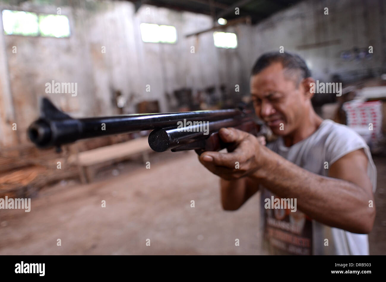 Ein Arbeiter testen die Genauigkeit der Waffe in einer kleinen Fabrik, Bestandteil der Luftgewehr-Industrie im Dorf Pare, in Indonesien Stockfoto