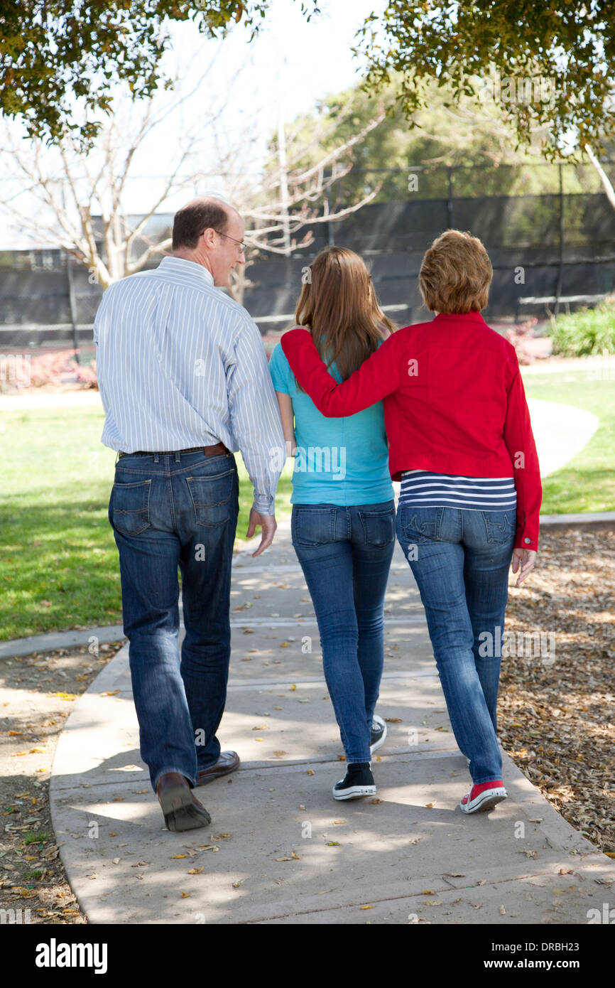 Rückansicht der Eltern mit Tochter zu Fuß auf einem Weg. Stockfoto