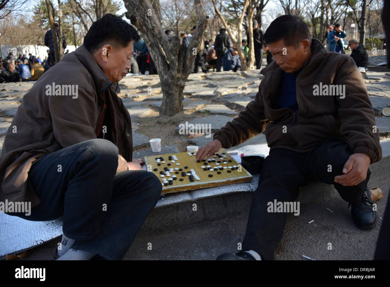 Zwei koreanische Männer spielen Baduk, auch bekannt als das chinesische gehen Spiel außerhalb der Gyeongbok Palast in Seoul, Südkorea, 27. März 2013. Bei günstigen Wetter treffen sich täglich Hunderte auf dem Platz vor dem Palast zu treffen, zu spielen oder Spieler konkurrieren in Baduk, Schach und andere Spiele zu sehen. Stockfoto