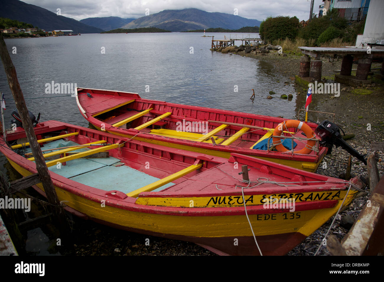 Rot und gelb Angelboote/Fischerboote am Strand in Puerto Eden Punta Arenas Patagonien Chile Südamerika gefesselt. Stockfoto