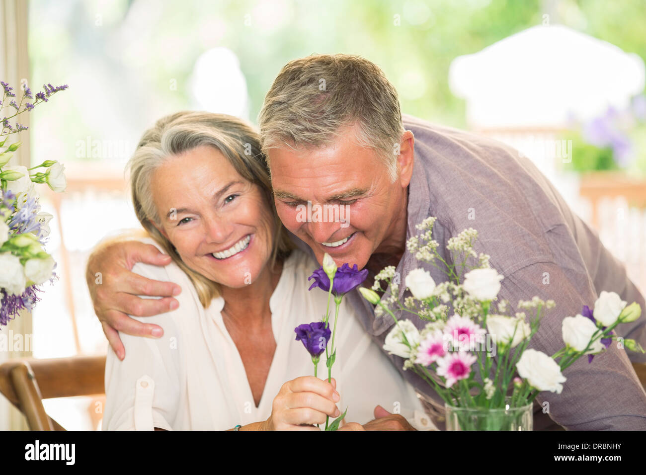 Älteres paar Blumen riechen Stockfoto