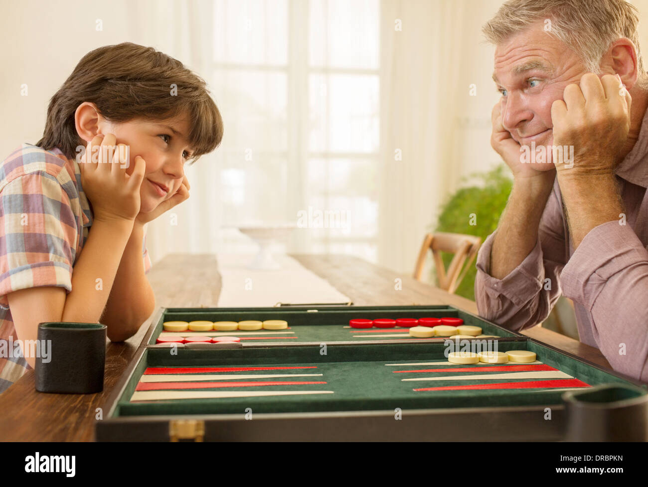 Großvater und Enkel spielen backgammon Stockfoto