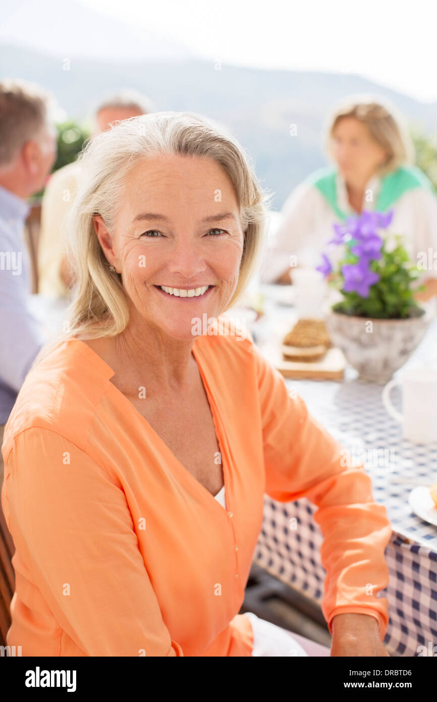 Ältere Frau lächelte Terrassentisch Stockfoto