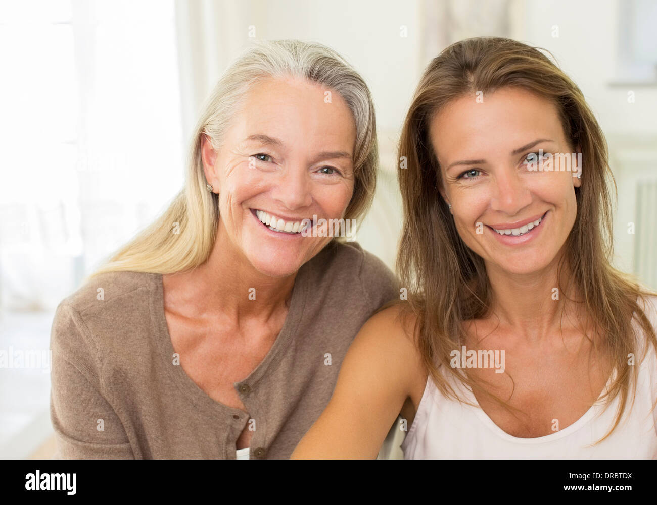 Mutter und Tochter lächelnd im Innenbereich Stockfoto