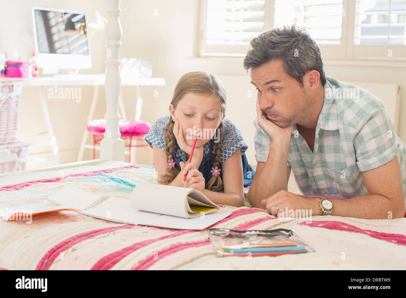 Vater-Tochter helfen bei den Hausaufgaben Stockfoto