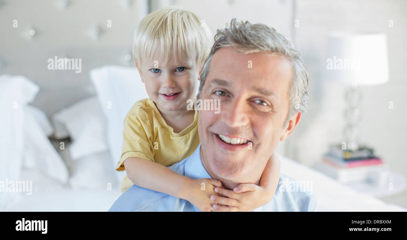 Vater und Sohn umarmt auf Bett Stockfoto
