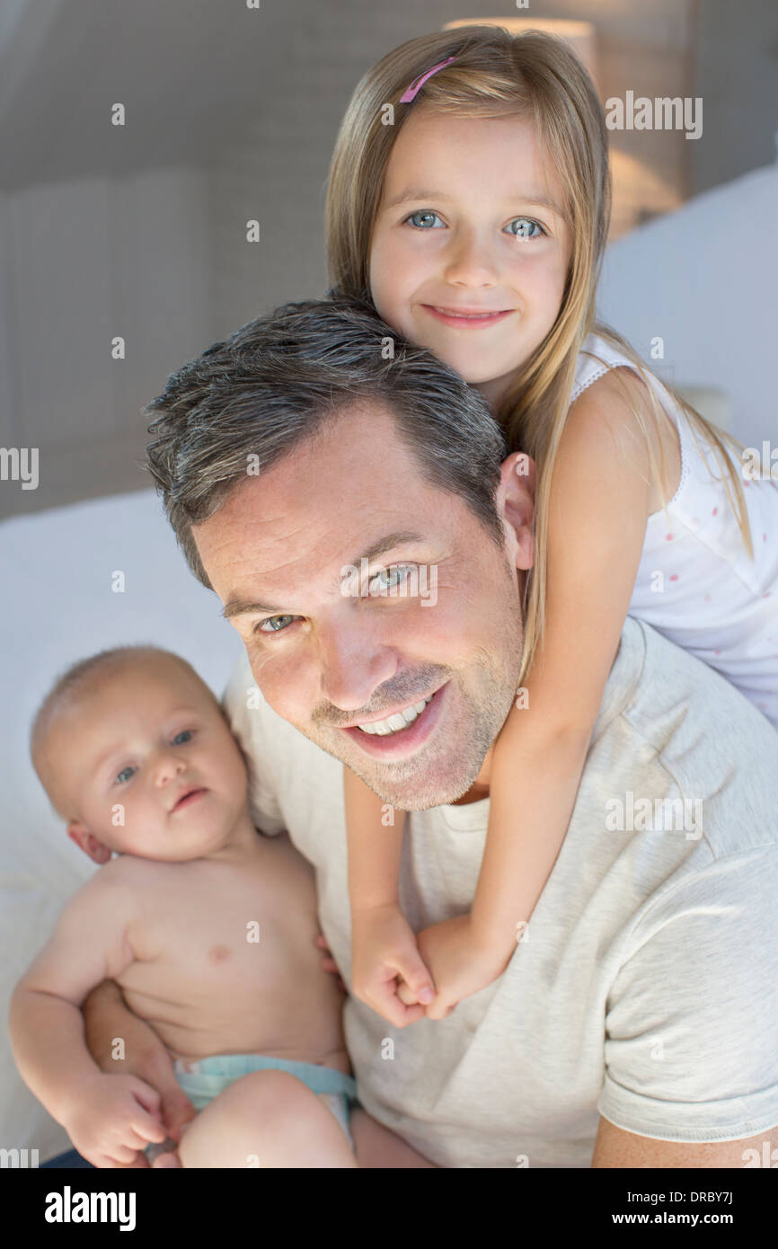 Vater und Kinder entspannend auf Bett Stockfoto