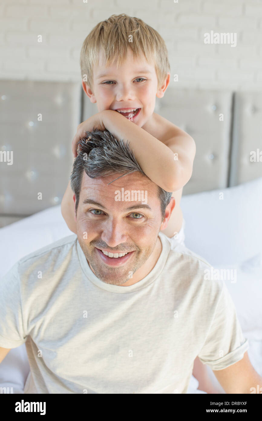 Vater und Sohn umarmt auf Bett Stockfoto