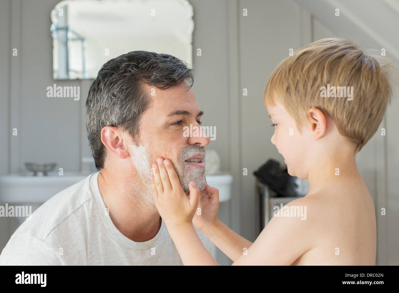 Junge Rasierschaum auf Vaters Gesicht reiben Stockfoto