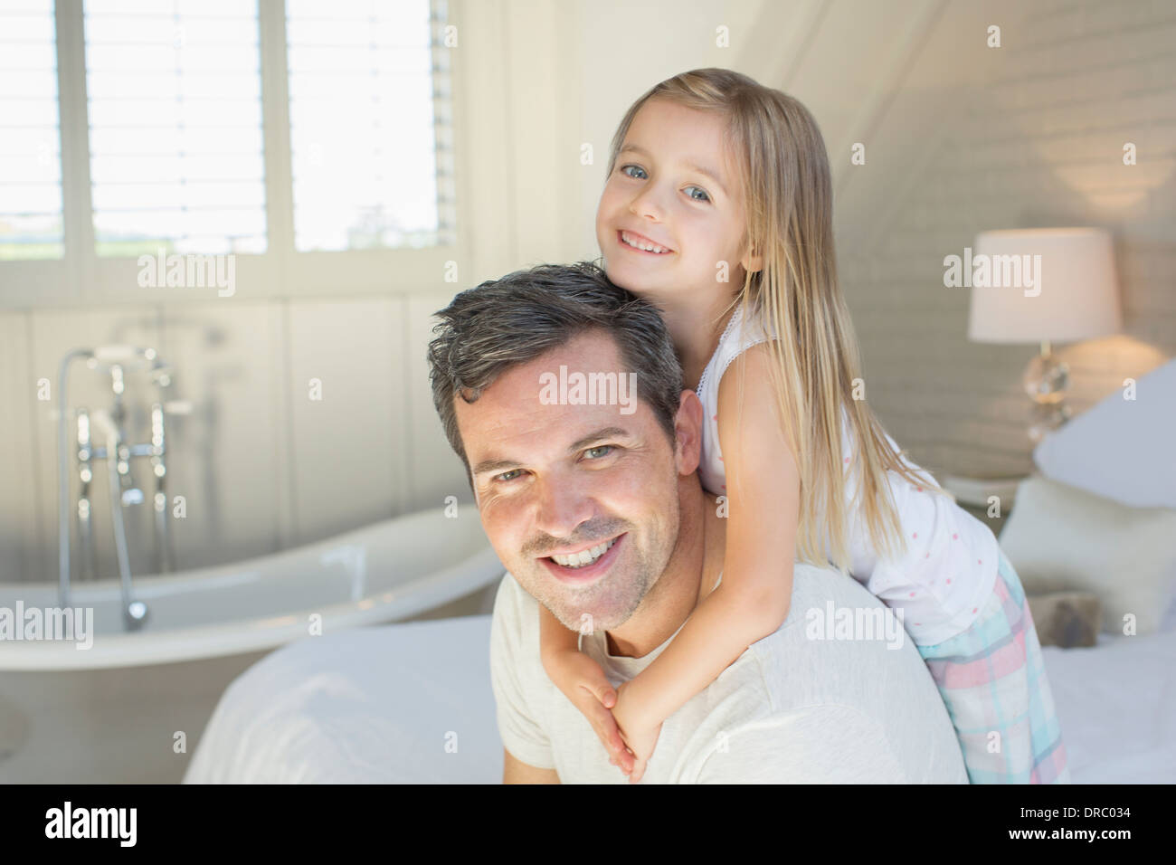 Vater und Tochter lächelnd in Schlafzimmer Stockfoto