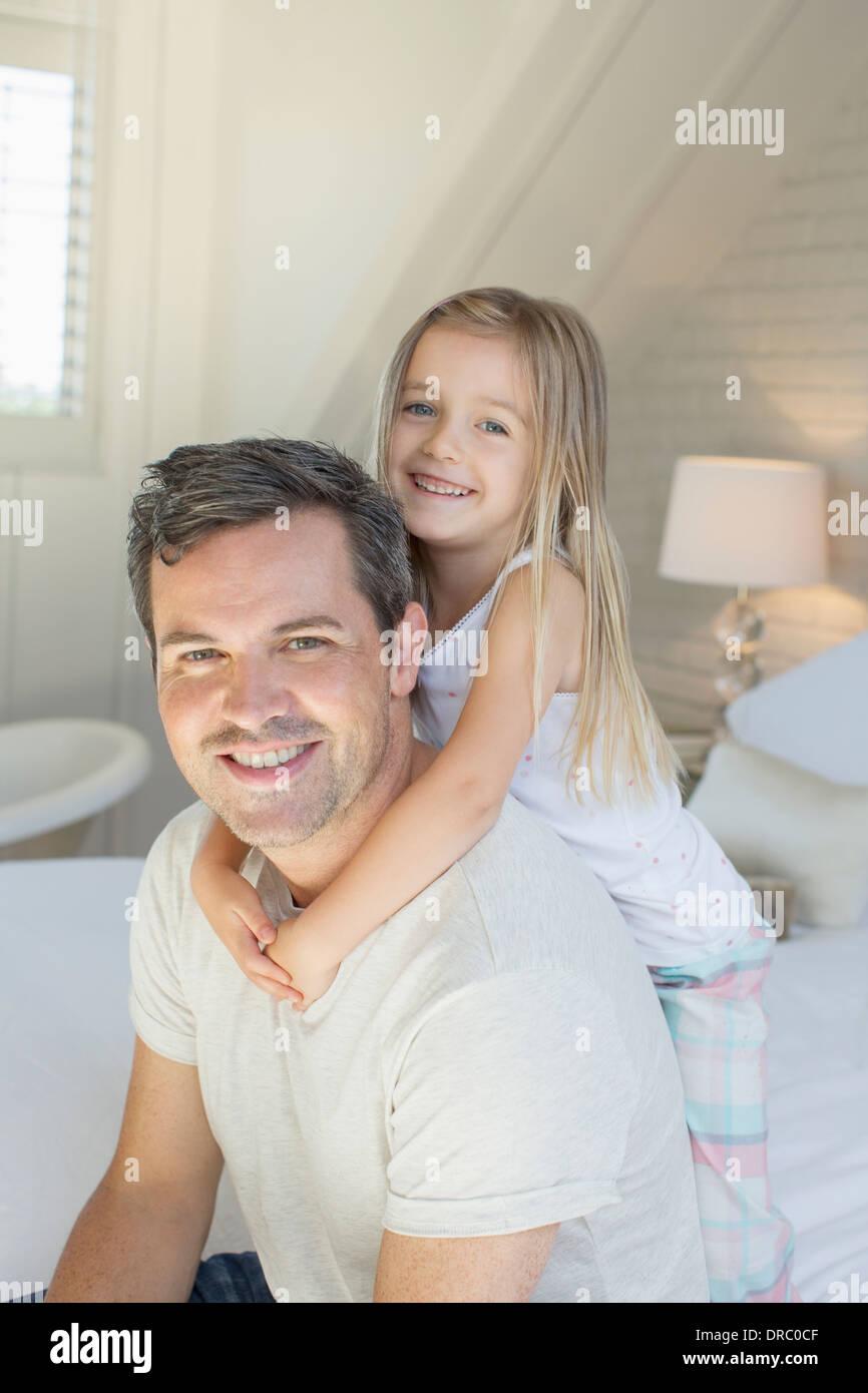 Vater und Tochter umarmt auf Bett Stockfoto
