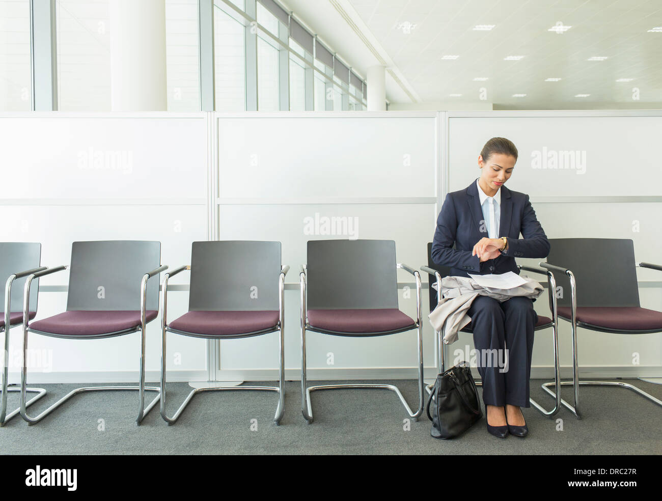 Geschäftsfrau Überprüfung Armbanduhr im Büro Stockfoto