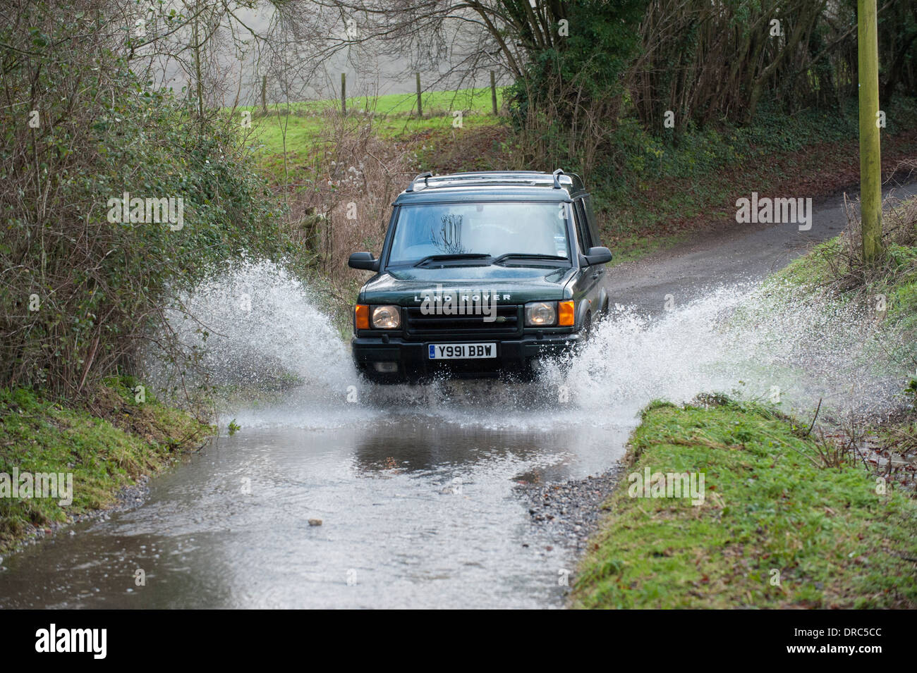 Land Rover Discovery 4 x 4 fahren durch Hochwasser auf einen Feldweg, Hampshire, UK Stockfoto
