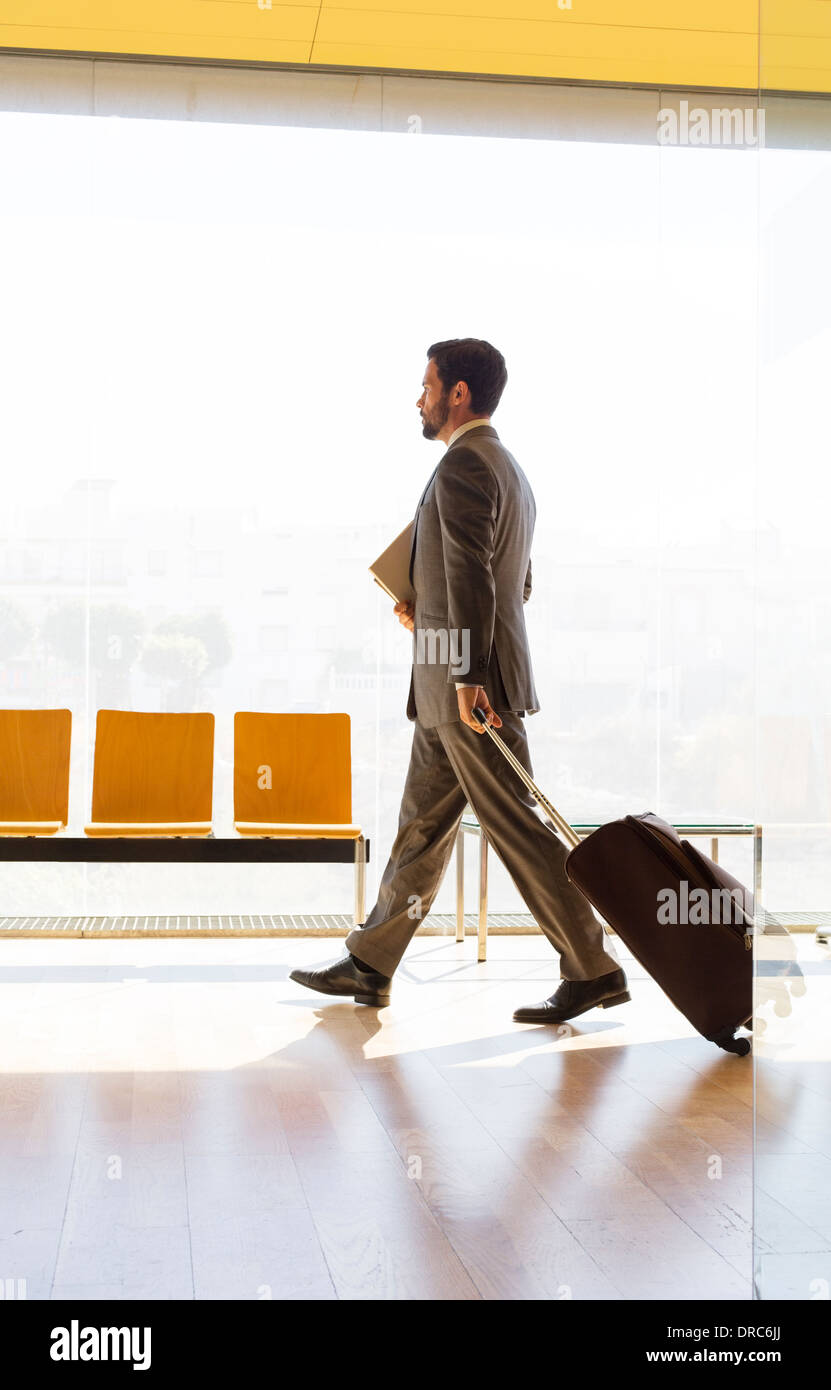 Geschäftsmann ziehen Koffer im Büro Stockfoto