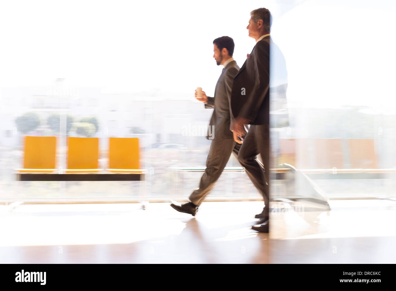 Geschäftsleute, die zu Fuß in Flughafen-Korridor Stockfoto