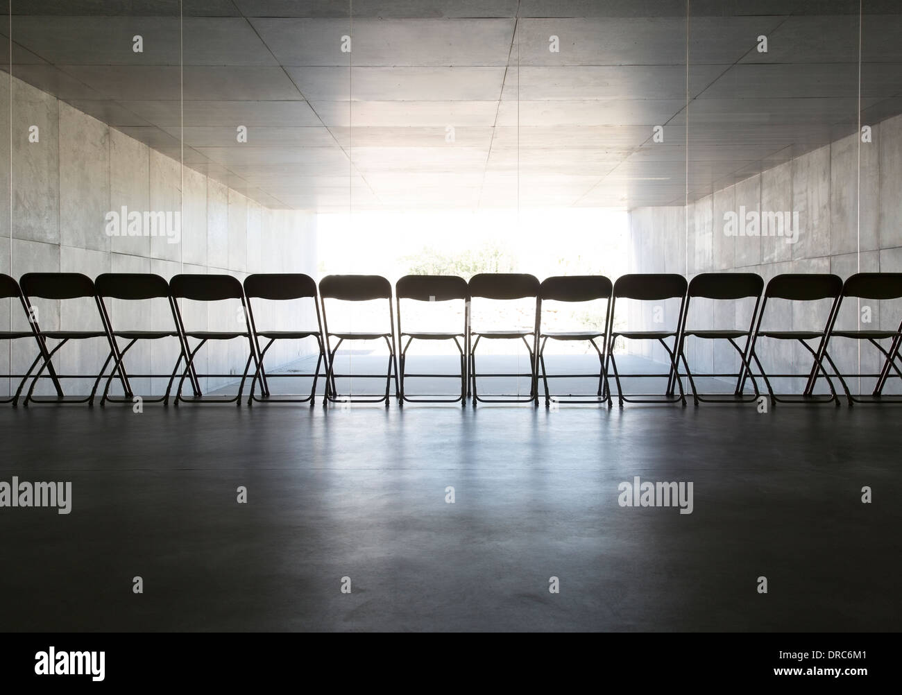 Silhouette von Bürostühlen, die hintereinander aufgereiht Stockfoto