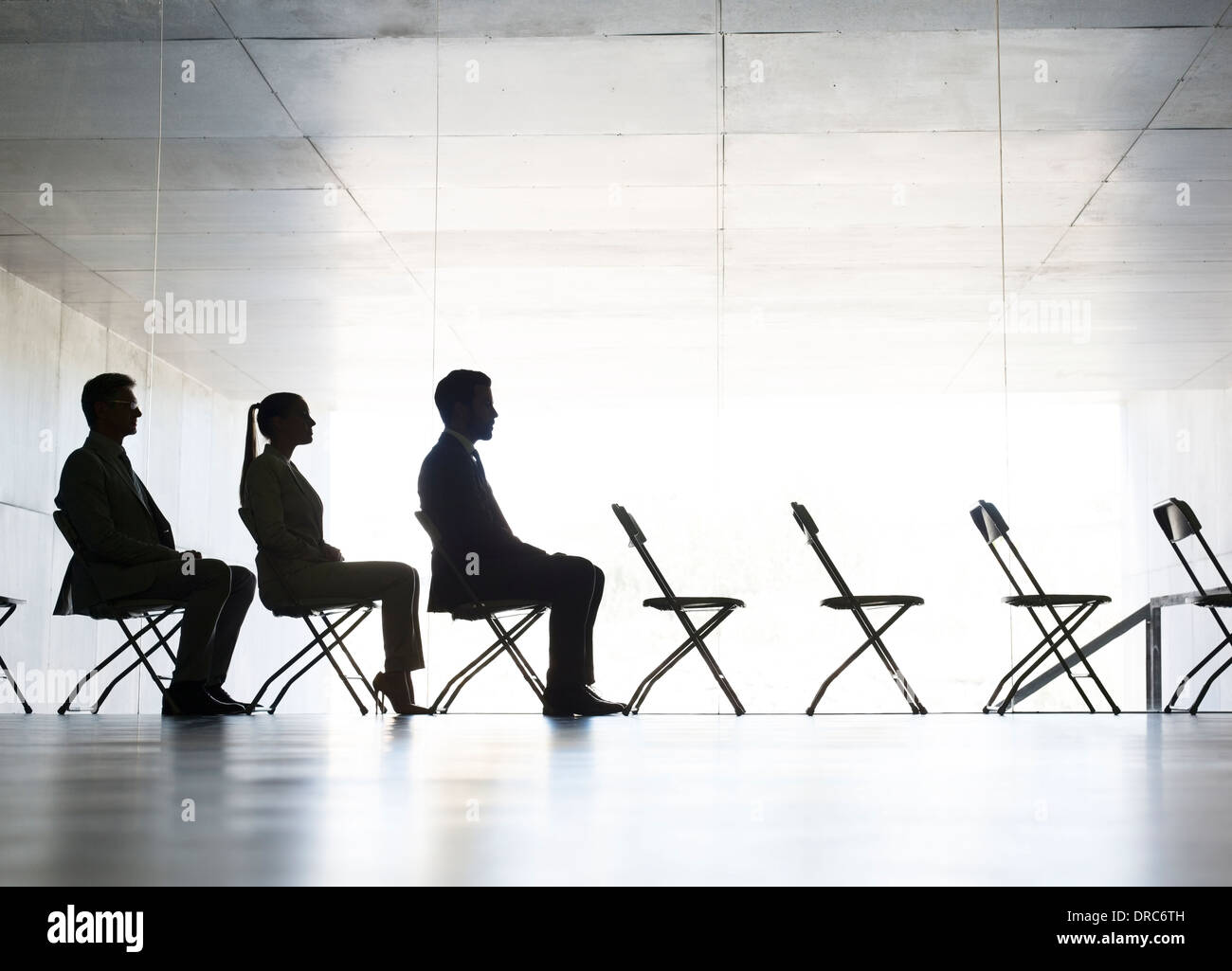 Business-Leute sitzen im Büro-Stühle in einer Reihe Stockfoto