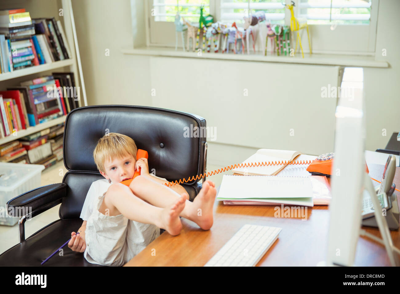 Junge am Telefon im Büro zu Hause Stockfoto