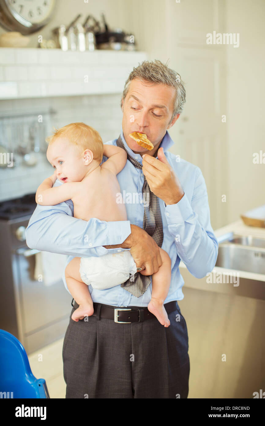 Vater Holding Baby und frühstücken Stockfoto
