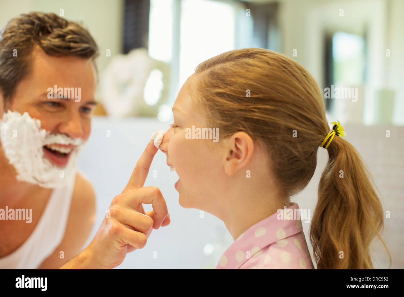 Vater und Tochter spielen mit Rasierschaum in Bad Stockfoto
