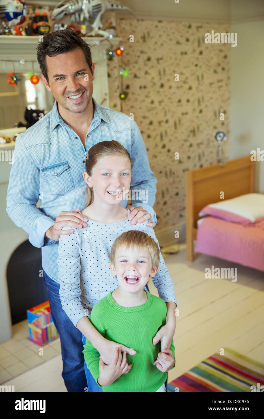 Vater und Kinder Lächeln im Schlafzimmer Stockfoto