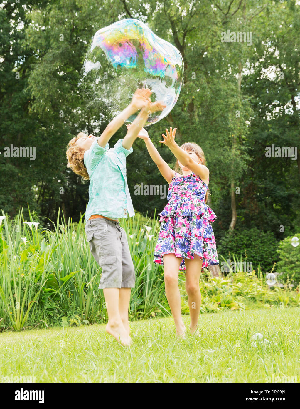 Kinder spielen mit Blase im freien Stockfoto